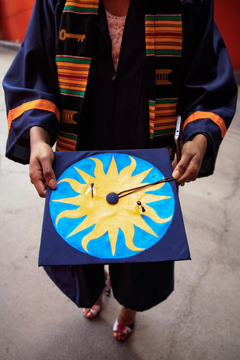 A student shows off her hand decorated graduation cap. 